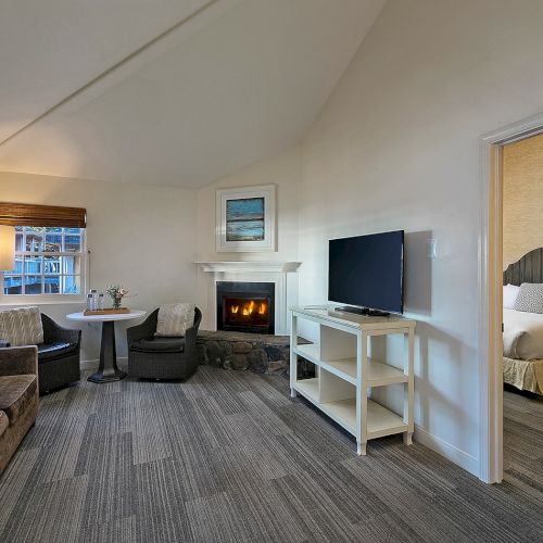 A bright hallway leading to a living room with seating, a piano, plants, and wall art, bathed in natural light.
